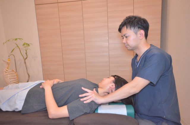 腱鞘炎と関わる首や上肢全体のつながりをみながら、頸部をやさしく施術している様子