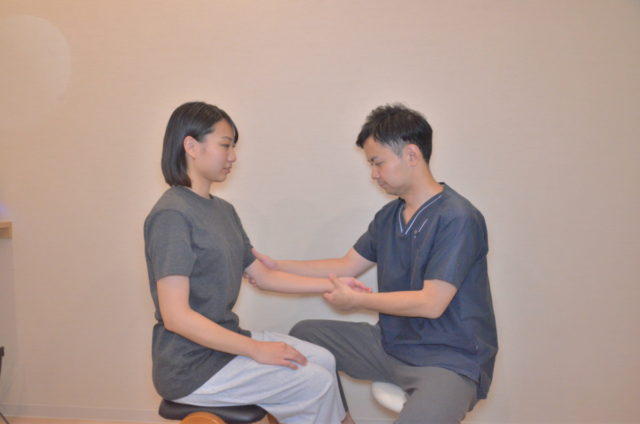 腱鞘炎に対して親指の付け根から手首、前腕にかけての状態を丁寧にみながら施術している様子